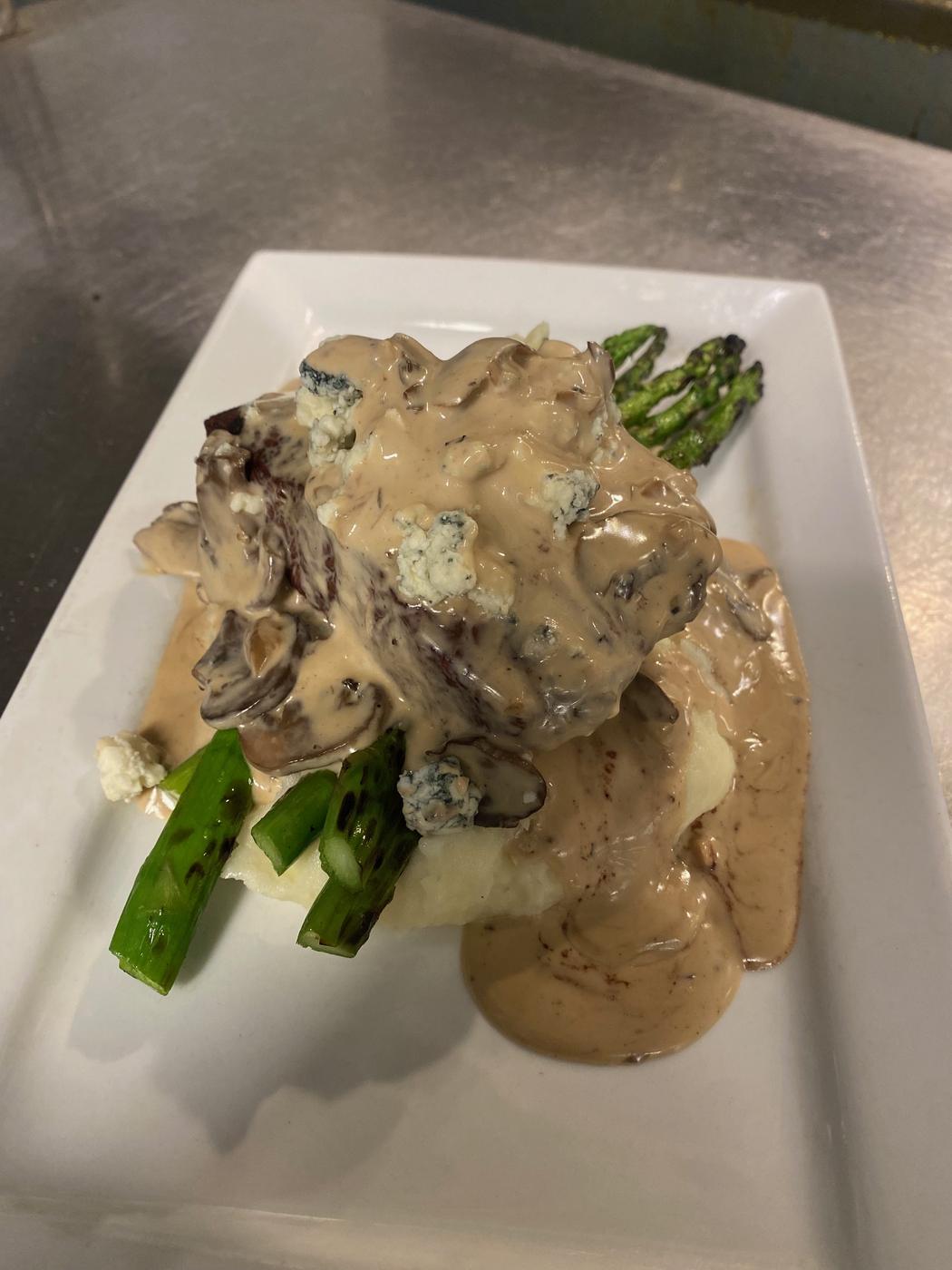 Chicken in a mushroom sauce with asparagus, plated for dinner